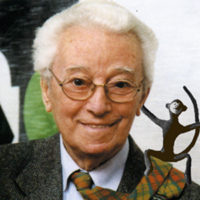 Ritratto di Bruno Munari che sorride con una piccola scimmia sulla spalla sinistra