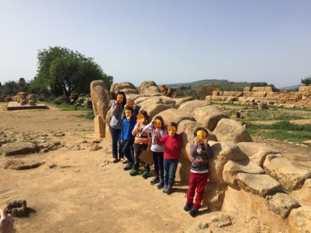 Foto di gruppo con la guida al telamone del tempio di Zeus indossando una maschera